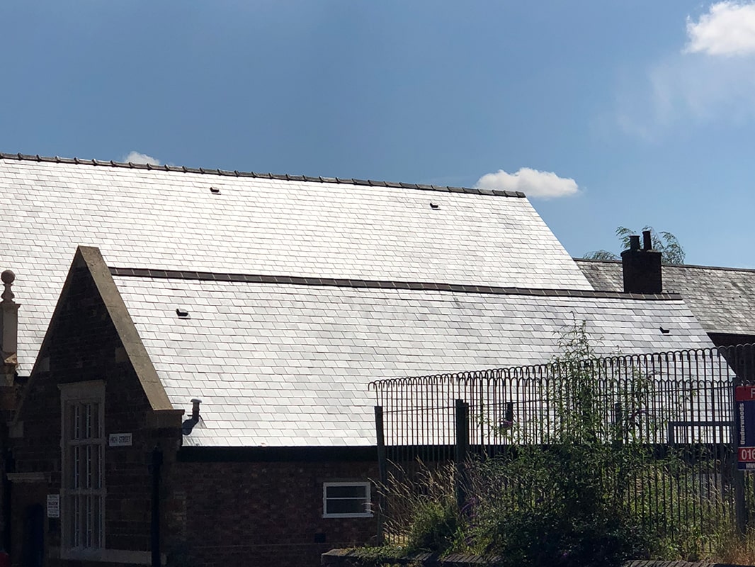 Large building with slate roofing after it has been repaired