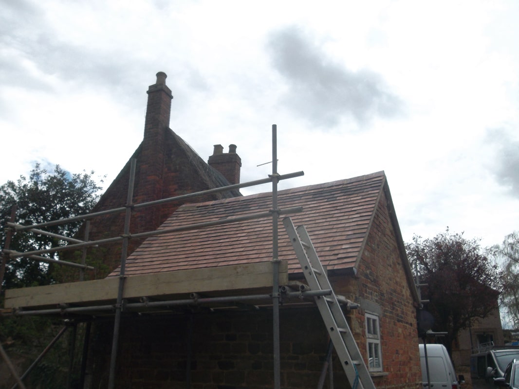 Tiled roof after it has been repaired surrounded by scaffolding